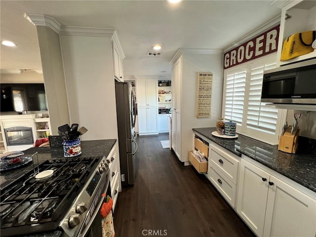 kitchen with white cabinetry, stainless steel appliances, dark hardwood / wood-style floors, dark stone countertops, and crown molding