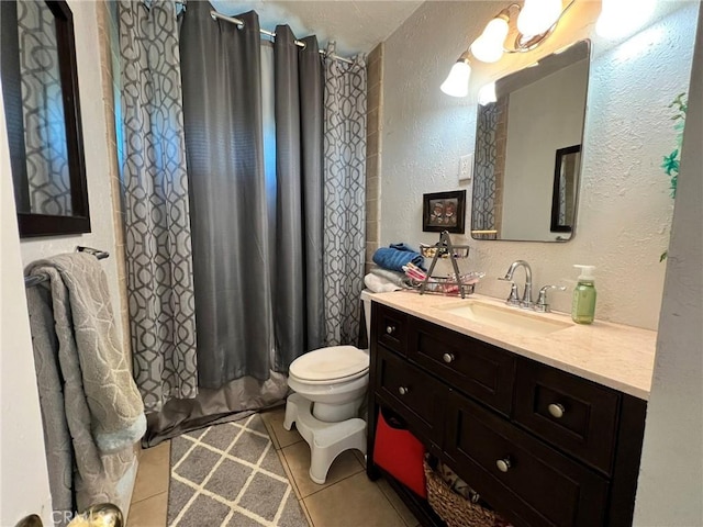 bathroom featuring toilet, vanity, and tile patterned flooring