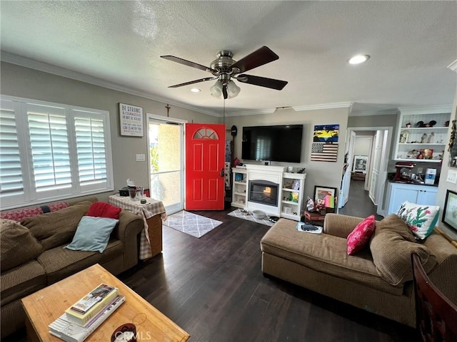 living room with a textured ceiling, dark wood-type flooring, ornamental molding, and ceiling fan