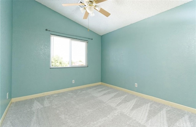 spare room featuring vaulted ceiling, ceiling fan, a textured ceiling, and light colored carpet