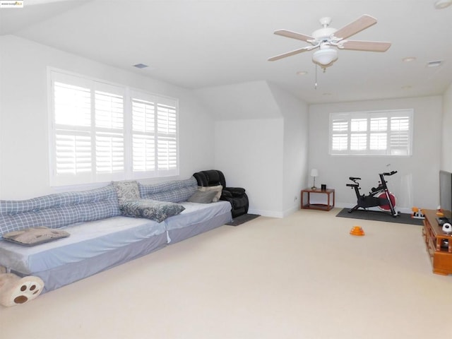 carpeted living room with lofted ceiling, ceiling fan, and plenty of natural light