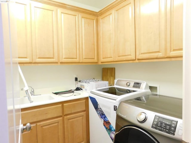 washroom with washer and dryer, sink, and cabinets