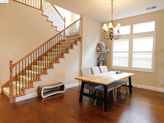 dining room featuring dark wood-type flooring and an inviting chandelier