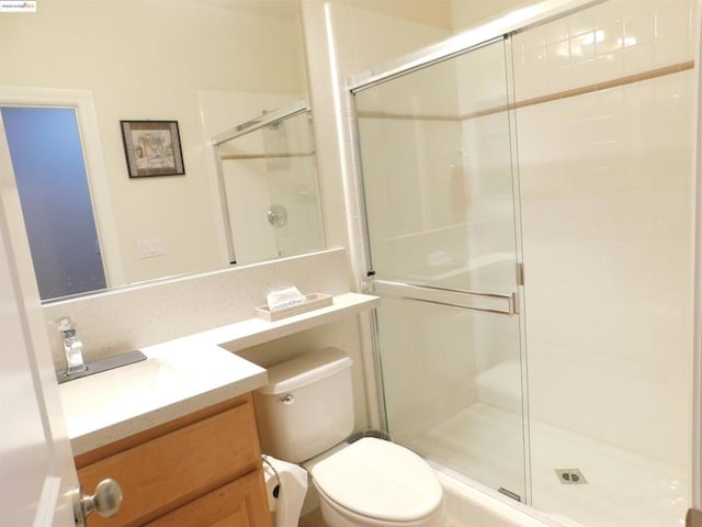 bathroom featuring toilet, an enclosed shower, and vanity