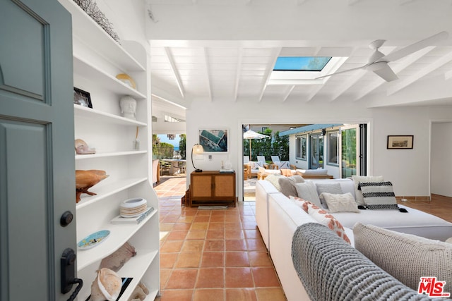 tiled living room featuring ceiling fan and vaulted ceiling with beams