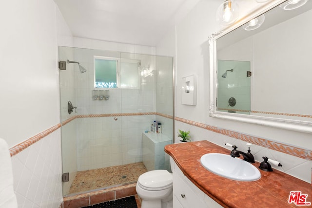 bathroom with toilet, backsplash, tile walls, walk in shower, and vanity