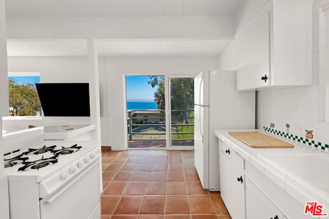 kitchen with decorative backsplash, a healthy amount of sunlight, white cabinets, and white appliances