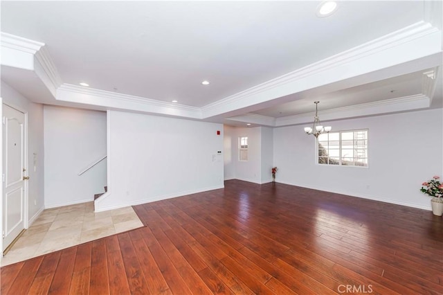 interior space featuring an inviting chandelier, crown molding, hardwood / wood-style floors, and a tray ceiling