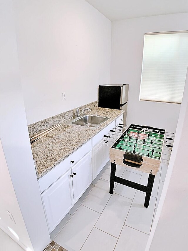 interior space featuring light tile patterned floors and sink