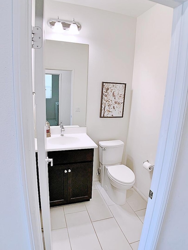 bathroom featuring toilet, vanity, and tile patterned flooring