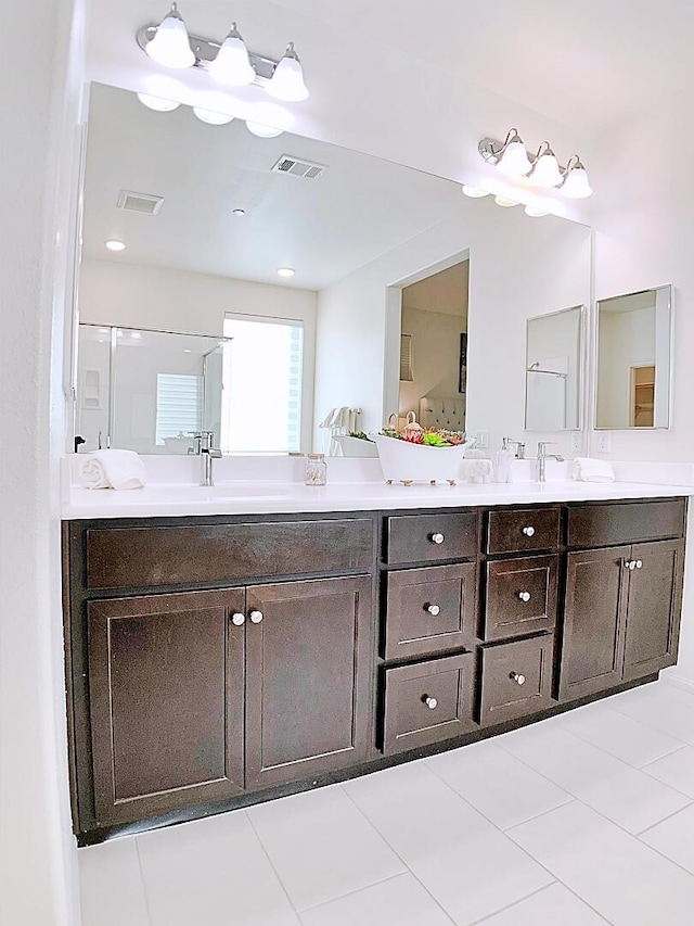 bathroom with tile patterned flooring, a shower with shower door, and vanity