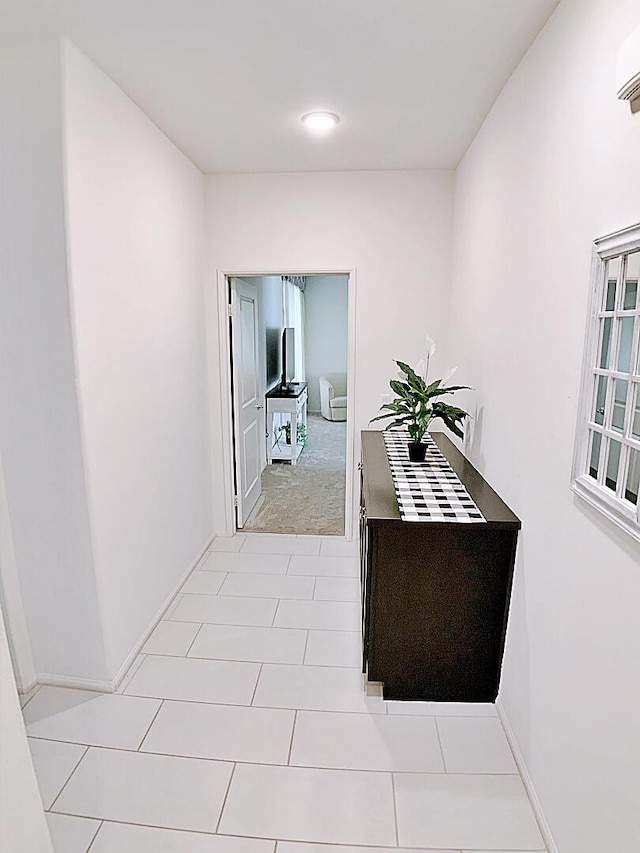 hallway featuring an AC wall unit and light tile patterned floors