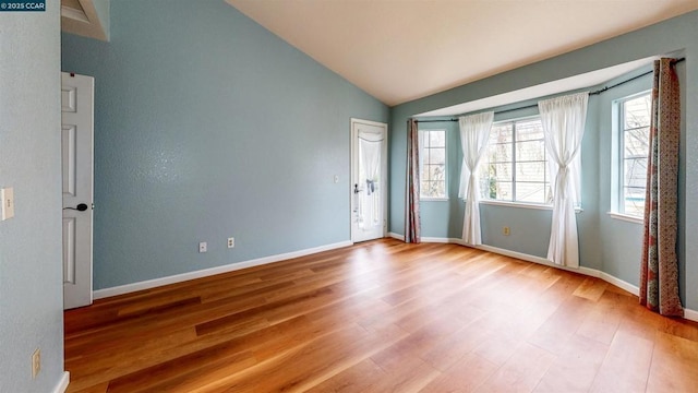 unfurnished room featuring light hardwood / wood-style flooring and lofted ceiling