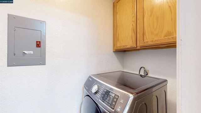 laundry room featuring electric panel, washer / dryer, and cabinets