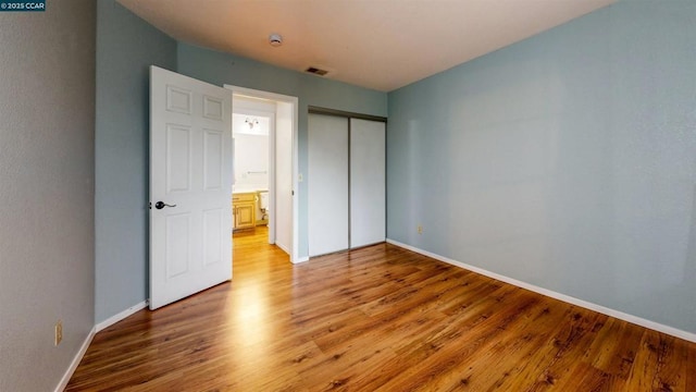 unfurnished bedroom with a closet and hardwood / wood-style flooring