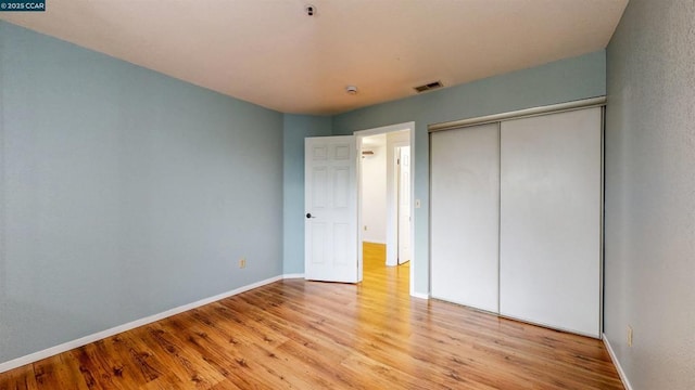 unfurnished bedroom with a closet and light wood-type flooring