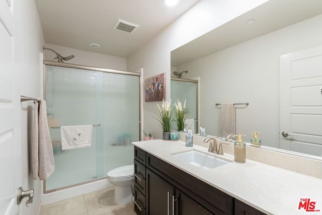 bathroom with vanity, toilet, walk in shower, and tile patterned floors