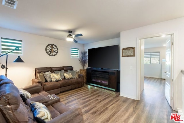 living room featuring wood-type flooring and ceiling fan