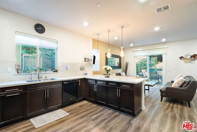 kitchen with dishwasher, decorative light fixtures, tasteful backsplash, sink, and kitchen peninsula