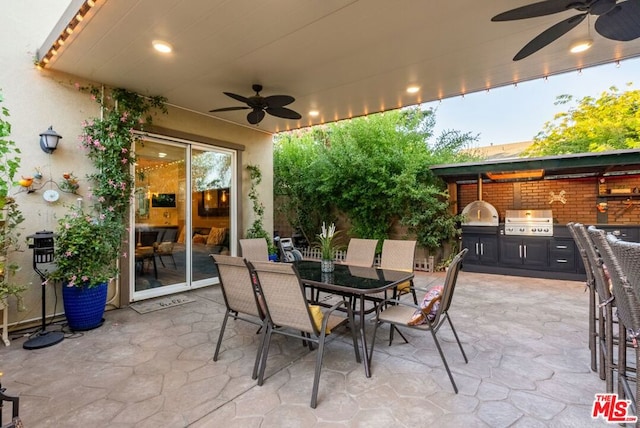 view of patio with exterior kitchen, a grill, and ceiling fan