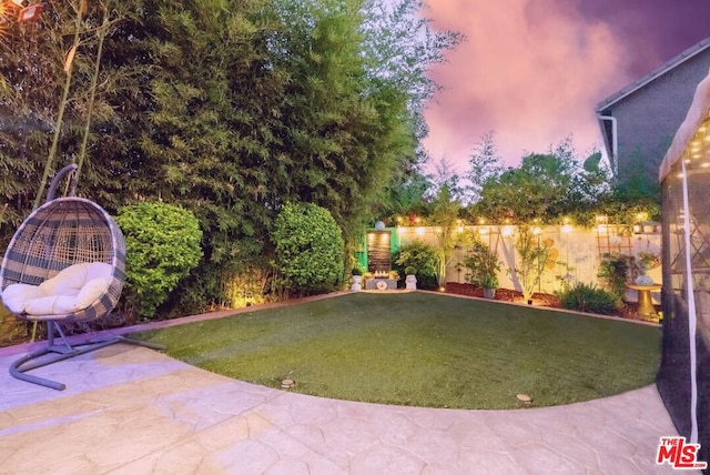 yard at dusk with a patio area