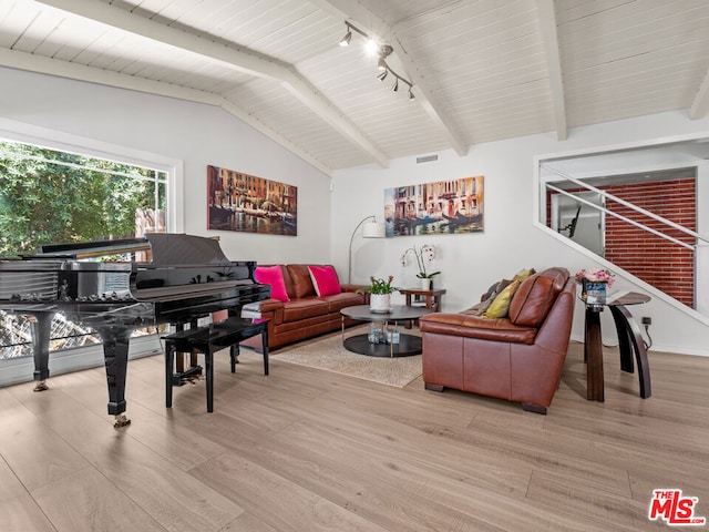 living room featuring vaulted ceiling with beams and light wood-type flooring