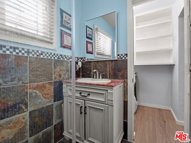 bathroom featuring hardwood / wood-style floors, built in shelves, and vanity