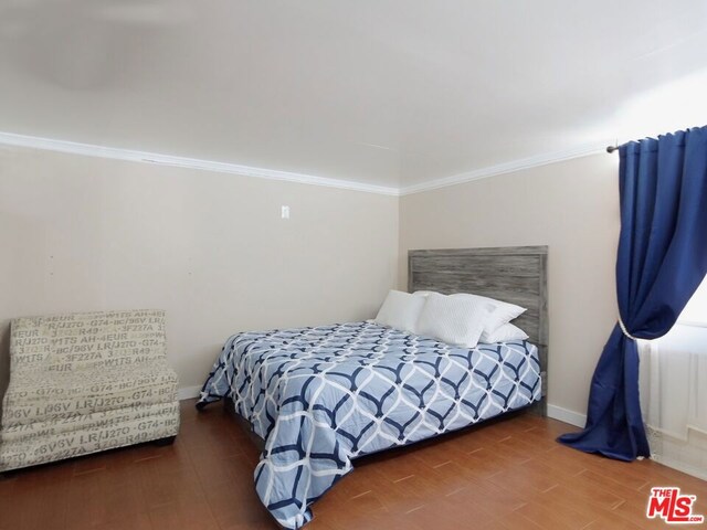 bedroom with crown molding and hardwood / wood-style flooring