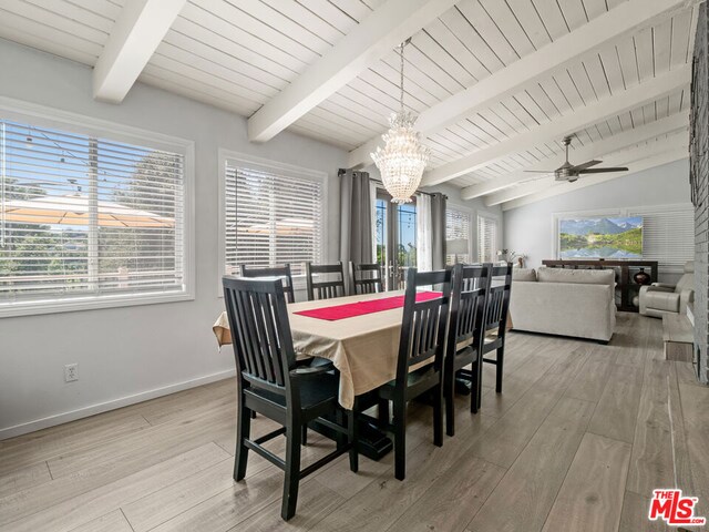 dining area with lofted ceiling with beams, light wood-type flooring, and ceiling fan with notable chandelier