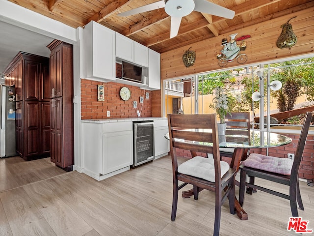 kitchen with light hardwood / wood-style flooring, stainless steel fridge, wine cooler, white cabinets, and wooden ceiling