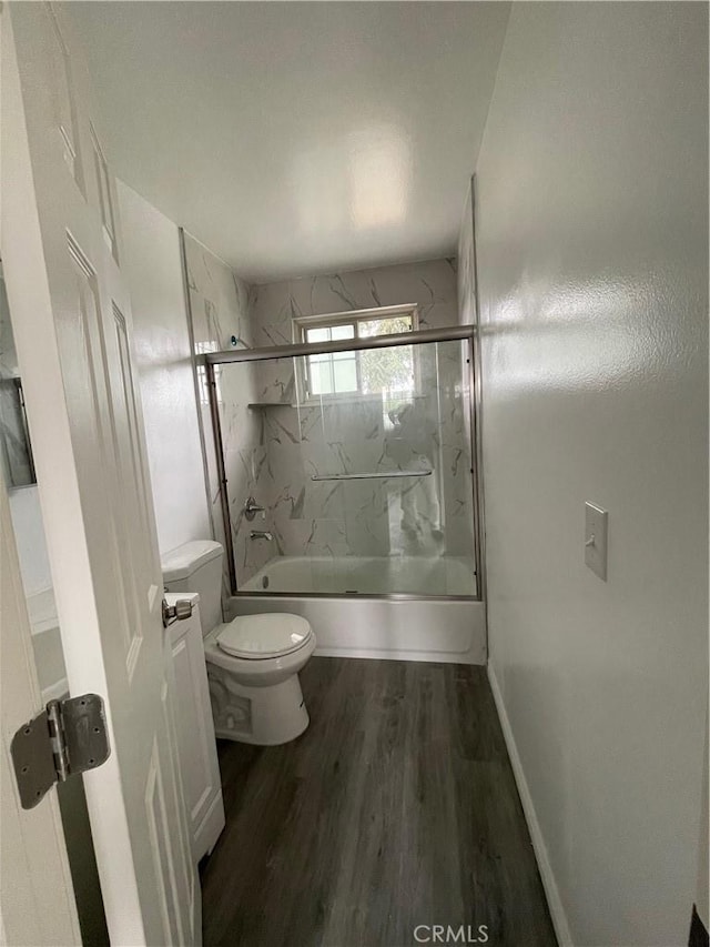 bathroom featuring toilet, enclosed tub / shower combo, and hardwood / wood-style flooring