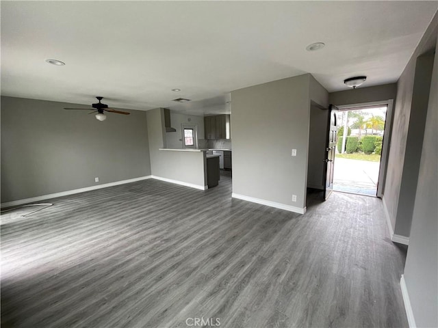 unfurnished living room featuring ceiling fan and dark hardwood / wood-style flooring