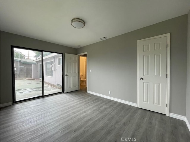 unfurnished bedroom with access to exterior and hardwood / wood-style floors