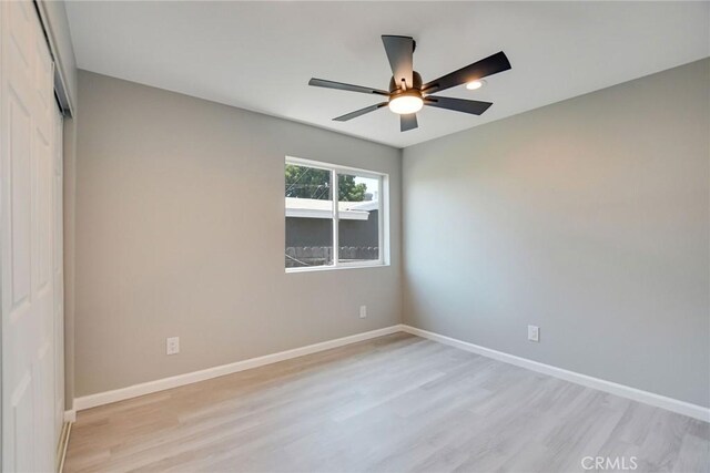 spare room with ceiling fan and light wood-type flooring