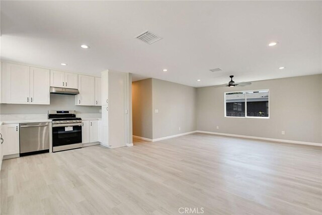 kitchen with ceiling fan, white cabinets, stainless steel appliances, and light wood-type flooring