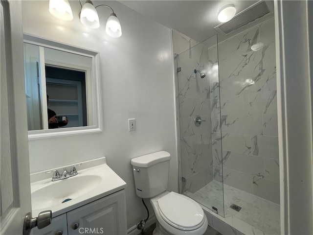 bathroom with toilet, vanity, and a tile shower