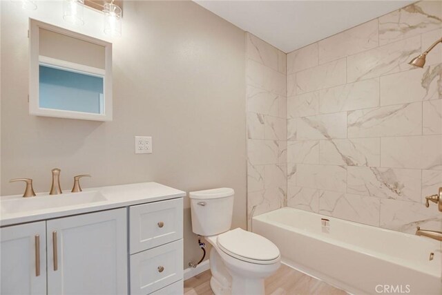 full bathroom featuring hardwood / wood-style floors, toilet, vanity, and tiled shower / bath