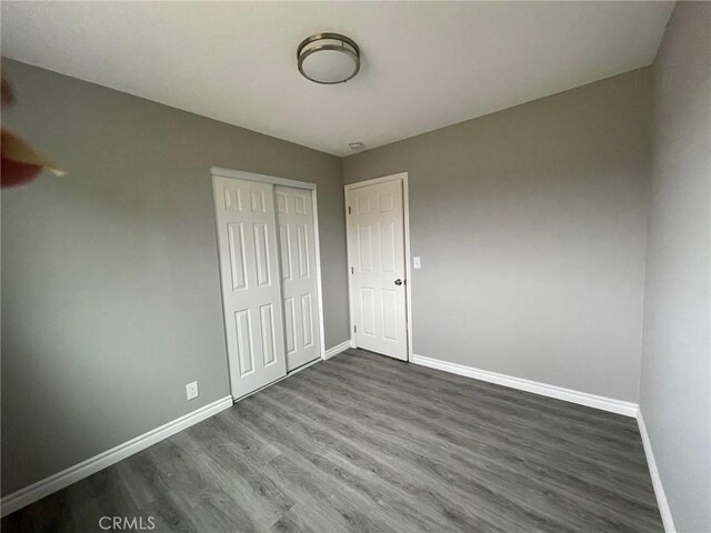 unfurnished bedroom featuring dark hardwood / wood-style floors and a closet