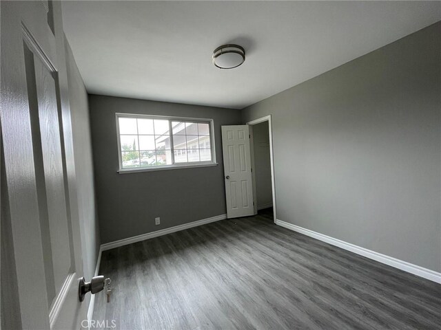 empty room with dark hardwood / wood-style flooring