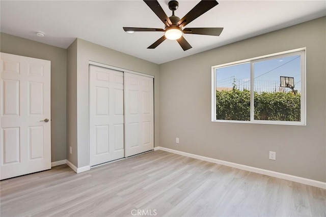 unfurnished bedroom with ceiling fan, a closet, and light hardwood / wood-style flooring