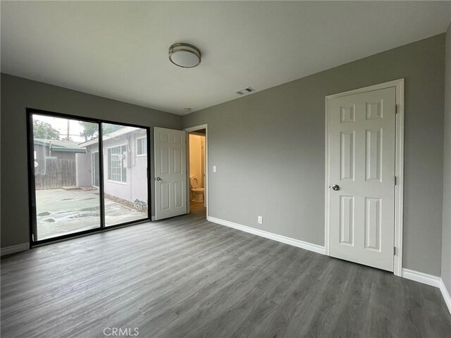 unfurnished bedroom featuring wood-type flooring and access to outside