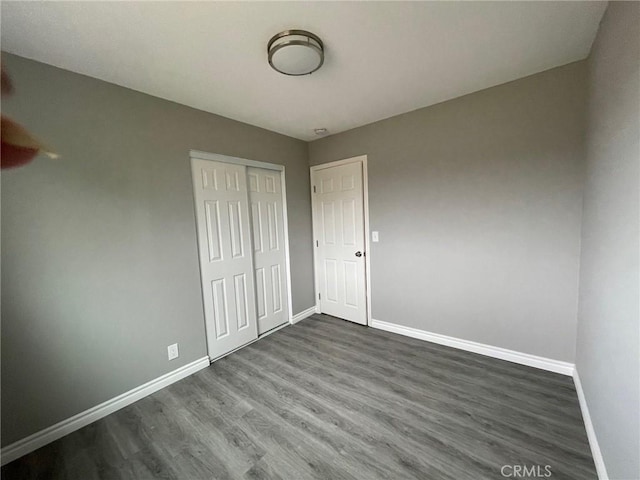 unfurnished bedroom with wood-type flooring and a closet