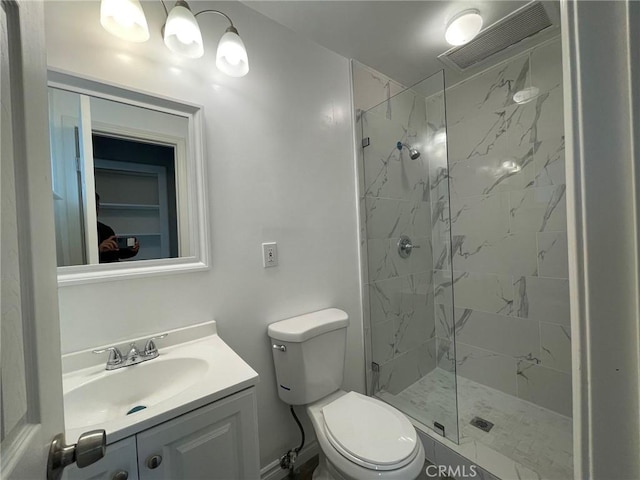 bathroom featuring toilet, vanity, and a tile shower