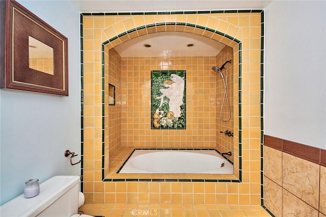 bathroom featuring tiled shower / bath combo and toilet