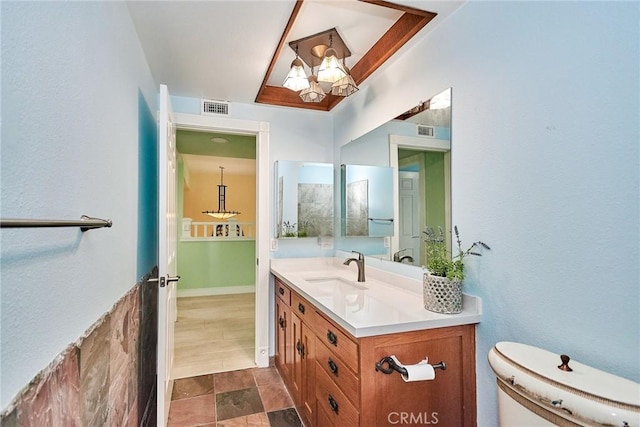 bathroom with toilet, visible vents, and vanity