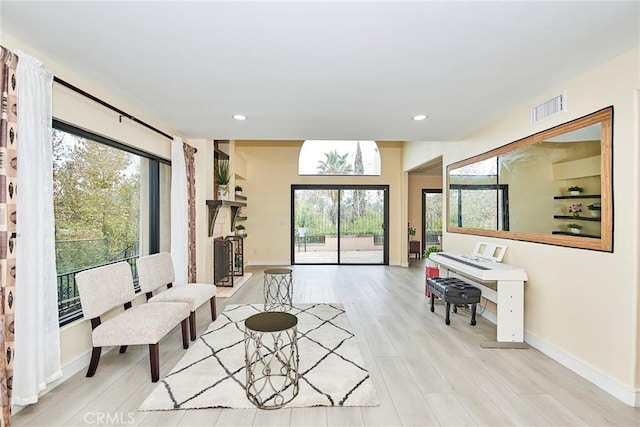 living area featuring a wealth of natural light and light hardwood / wood-style flooring