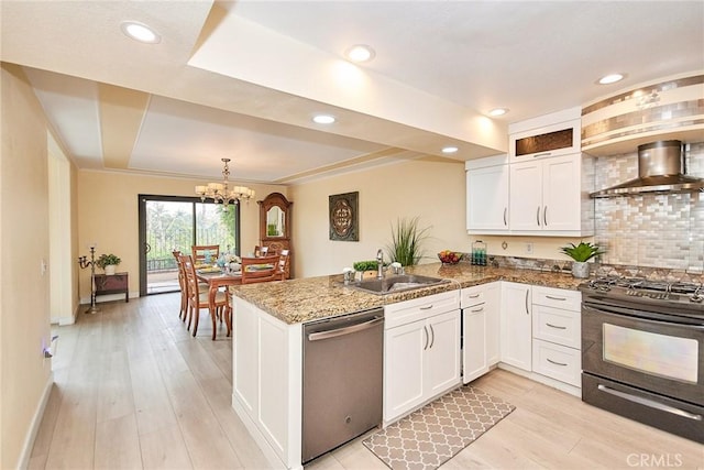 kitchen with black gas range, white cabinets, wall chimney exhaust hood, and dishwasher