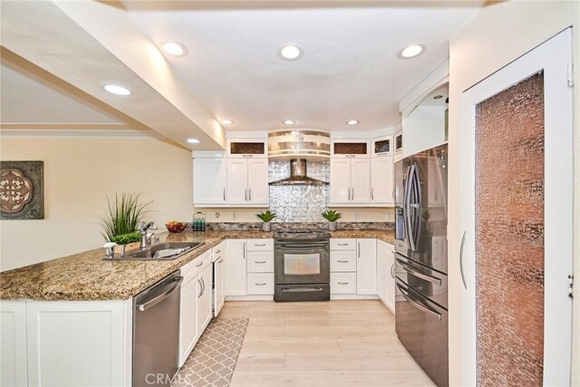 kitchen featuring sink, dark stone countertops, stainless steel appliances, white cabinets, and kitchen peninsula