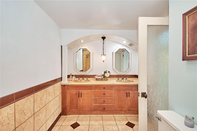 bathroom featuring double vanity, tile patterned flooring, a sink, and toilet