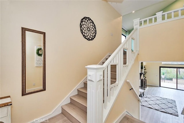 stairway with wood finished floors and baseboards